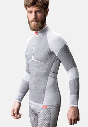 Langsleeve basislaag shirt en legging in lichtgrijs met textuurpatronen, contrasterende gebieden en een korte rits halslijn.