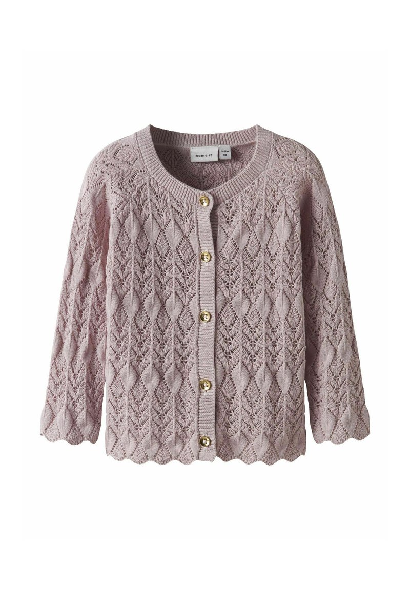 Stickad cardigan i mjuk rosa, med ett öppet diamantmönster, rund sprund och scalloped fåll. Fäst med knappar i guldton.