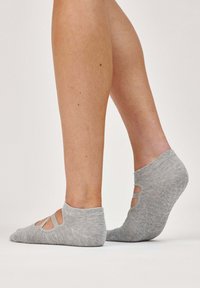 Calzini invisibili grigi con design ritagliato e motivo antiscivolo sulla suola. Materiale a maglia con una texture morbida.