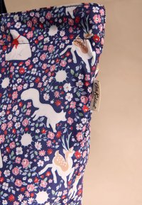 Tengerészkék szövet táska virágmintával, fehér állatokkal, például rókával és jávorszarvassal, valamint márkajelzéssel az oldalán.