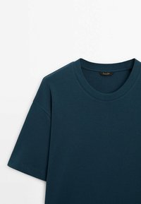 Donkergroene korte mouw T-shirt met een ronde halslijn, gemaakt van zacht materiaal, met een gladde textuur en minimale details.
