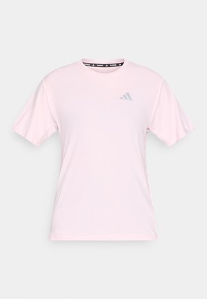 T-shirt de sport rose pâle à manches courtes, col rond, avec une texture subtile. Présente un petit logo gris sur le devant et un col à motif.