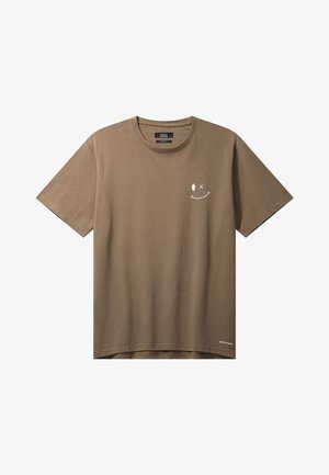 Barna rövid ujjú, kerek nyakú póló, bal mellrészen egy kis fehér mosolygós arc grafikával és az alsó szegély közelében finom szöveggel.