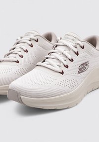 Zapatillas deportivas blancas con parte superior texturizada y paneles de malla, con acentos grises, punta redondeada y suela acolchada para mayor soporte.