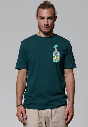Dark green cotton t-shirt featuring a bottle graphic with a palm tree and beach scene in vibrant colors, round neck, and short sleeves.