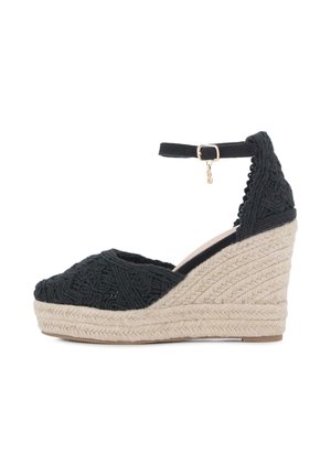 Sandalia cuña negra de ganchillo con tira en el tobillo y plataforma y tacón de yute trenzado beige.