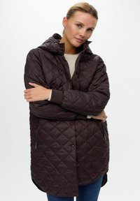 Gequilted donkerbruine pufferjas met een capuchon, voorzien van ritszakken aan de zijkant, geribbelde manchetten en een knoopsluiting. De stof heeft een glanzende afwerking.