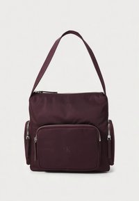 Burgunderfarget skulderveske i nylon med hovedrom som kan lukkes med glidelås, frontlomme og to sidelommer; har logodetalj på fronten.