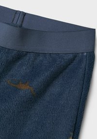 Tissu en polaire marine avec une texture douce, présentant une taille élastique lisse et un motif accent brun subtil.