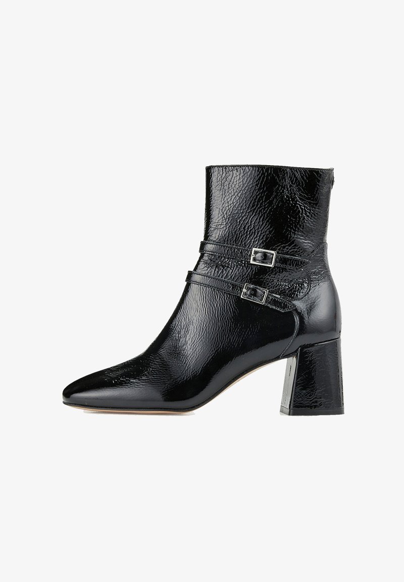 Bottine en cuir verni noir avec bout pointu, deux brides décoratives à boucles argentées et talon bloc.