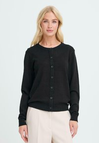 Cardigan nero in tessuto a coste, con maniche lunghe, scollo rotondo e chiusura frontale con bottoni. Presenta bottoni neri coordinati.