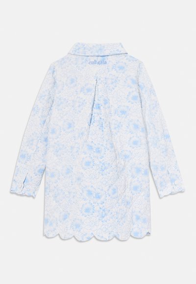 Floral-patterned long-sleeve shirt in white and light blue, with a spread collar and scalloped hem. Textured fabric with a pleat detail at the back.