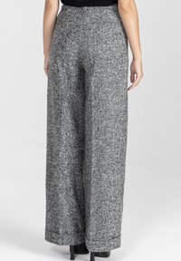 Spodnie o szerokich nogawkach wykonane z teksturowanej szarej tkaniny, z wysokim stanem i gładkim wykończeniem, bez widocznych elementów metalowych czy wzorów.