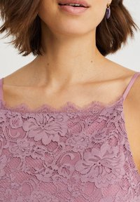 Spetslinne i mjuk lavendel med blomster mönster, vågiga kanter och tunna justerbara band.