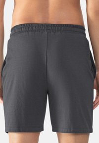 Dark gray athletic shorts with an elastic waistband, side pockets, and a smooth texture, ending just above the knee.