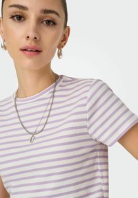 Lilla og hvid stribet kortærmet T-shirt med ribbet tekstur, parret med en sølv kædedesign og små hoopsøreringe.