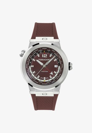 Zegarek Ferragamo GMT Timezoner z brązową tarczą i teksturowanym gumowym paskiem, srebrną kopertą, okienkiem daty oraz oznaczeniami stref czasowych światowych miast.