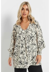 Blommig blus i kräm med svart botaniskt tryck, V-urringning, långa ärmar med samlade manschetter och en avslappnad passform.