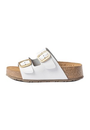 Weißer Lederslide-Sandel mit Korkfußbett, zwei verstellbaren Riemen mit goldenen Schnallen und einer strukturierten braunen Gummisohle, Seitenansicht.