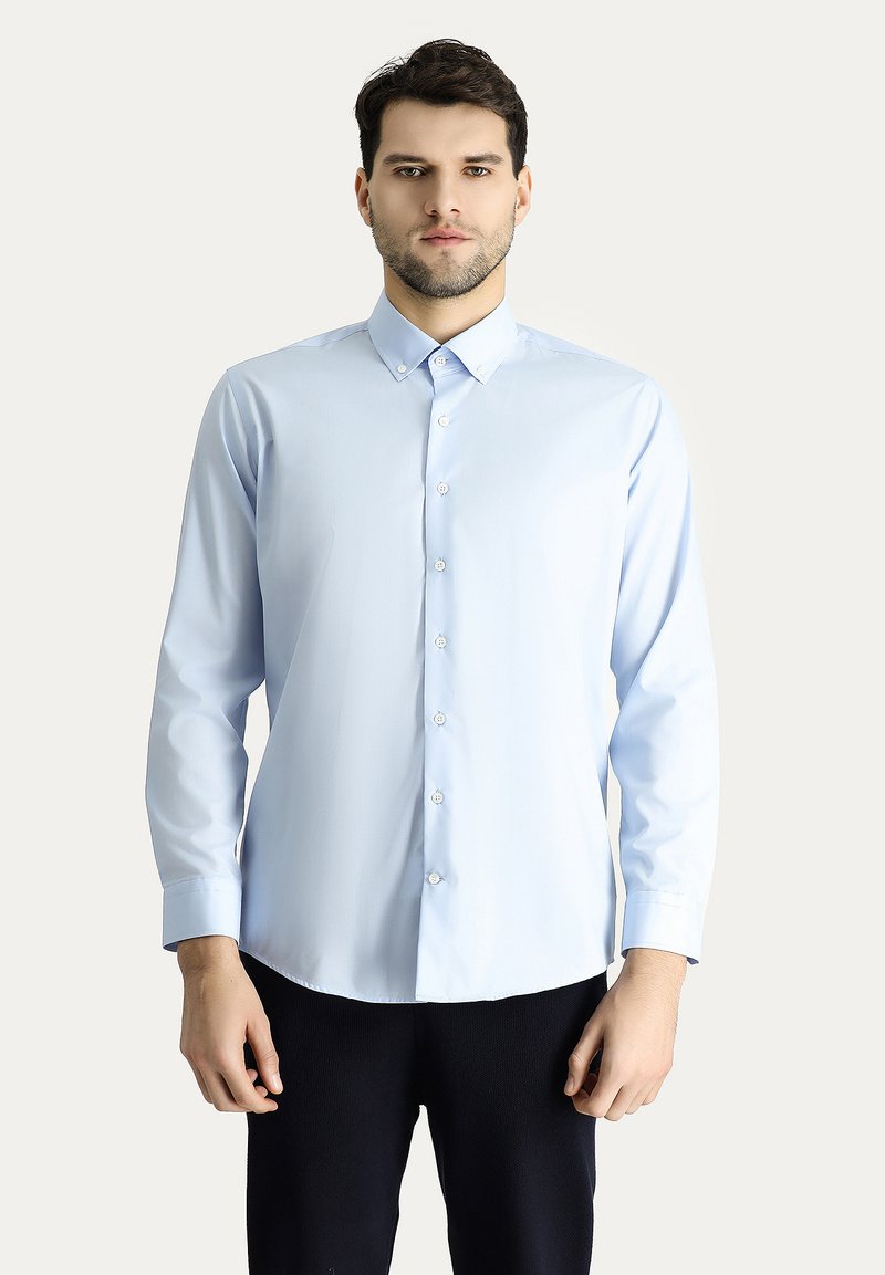 Camicia azzurra a maniche lunghe con colletto alla francese, texture liscia e chiusura frontale con bottoni. Design semplice, senza fantasie o accenti.