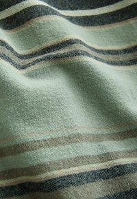 Soft fabric with horizontal stripes in muted green, black, brown, and beige, showing folds and texture up close.