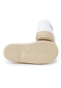 Chaussure blanche à enfiler avec une tige en tissu texturé, une semelle intermédiaire en jute et une semelle en caoutchouc dotée d'une empreinte à motifs pour une meilleure adhérence.