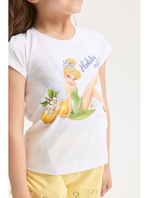 Dziewczyna w białej koszulce z zieloną wróżką siedzącą na liściach, otoczoną cytrynami i białymi kwiatami, w połączeniu z żółtymi szortami.