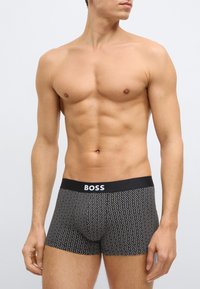 Fekete boxeralsó fehér pöttyös mintával és fekete derékpánttal, amelyen fehér "BOSS" logó található. Puha anyag és testhezálló kialakítás.