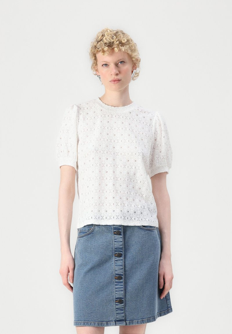 Witte oogjes kant blouse met poffende mouwen, ronde hals, gecombineerd met een denimrok met een sluiting aan de voorkant en twee zakken.