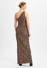 Robe maxi à motif léopard avec design asymétrique, fabriquée en tissu doux, présentant une silhouette ajustée et une fente sur le côté pour un meilleur confort de mouvement.