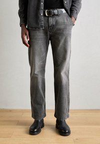 Grijze denim jeans met een rechte snit, lichte vervaging en een reguliere tailleband. Draag ze met zwarte enkellaarzen, gemaakt van een gladde leren textuur.
