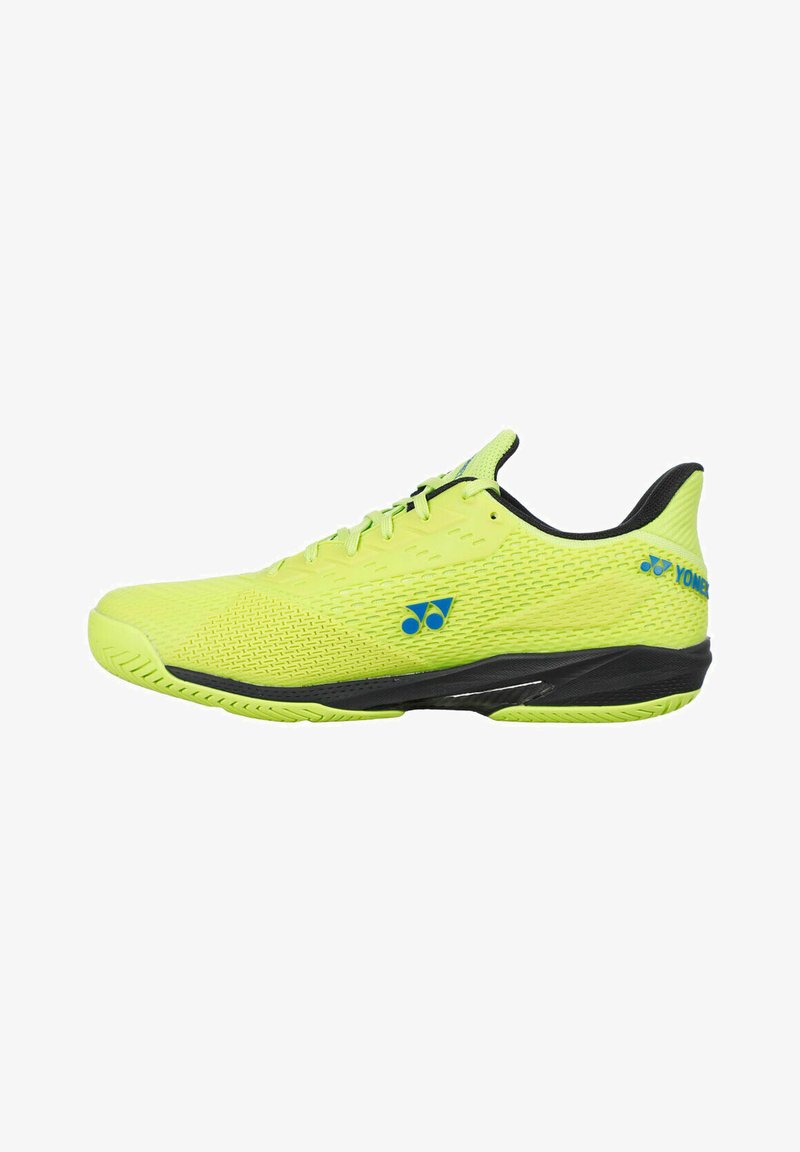 Chaussure de sport jaune vif avec semelle et intérieur noirs, logos Yonex bleus sur le côté et le talon, conçue pour la performance sportive.