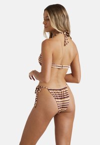 Completo bikini a righe con top a fascia con chiusura a lacci e slip a vita bassa con lacci laterali e dettagli arricciati, in tonalità calde.