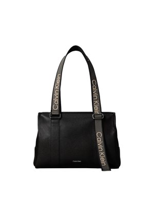 Μαύρη τσάντα Calvin Klein με υφή από κόκκους, δύο λουριά ώμου τυπωμένα με το λογότυπο και ένα μικρό λογότυπο Calvin Klein μπροστά.