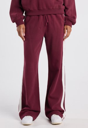 Bordeaux joggings met een relaxte pasvorm, voorzien van witte zijstrepen, een elastische tailleband en een zachte, gestructureerde stof.