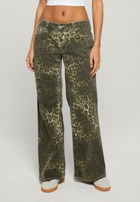 Szerokie jeansy w oliwkowym kolorze z wzorem w panterkę, z kontrastowymi przeszyciami i przednimi kieszeniami. Miękka tkanina dżinsowa.