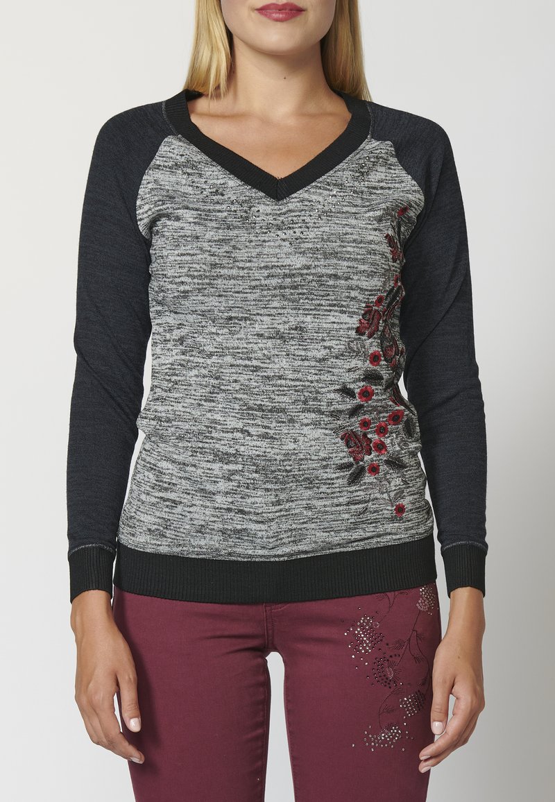 Grau und schwarzer Strickpullover mit V-Ausschnitt, mit rotem floralem Stickereimuster an der Seite sowie gerippten Bündchen und Saum.