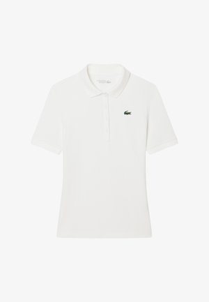 Polo bianco con maniche corte, colletto e patta con tre bottoni. Presenta un piccolo logo verde Lacoste sul lato sinistro del petto.