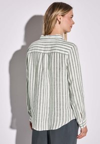 Camicia a maniche lunghe a righe verdi e bianche con colletto abbottonato, retro plissettato e orlo arrotondato; realizzata in tessuto leggero.