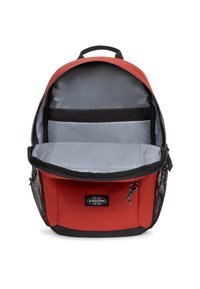 Sac à dos rouge avec un intérieur gris, doté d'une fermeture éclair, d'une poche intérieure et de poches latérales en maille noires. Tissu durable et design épuré.