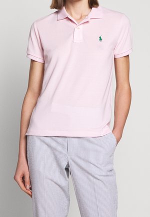 Lichtroze poloshirt van katoen, met een groen geborduurd logo op de linkerborst, voorzien van een klassieke kraag en korte mouwen.