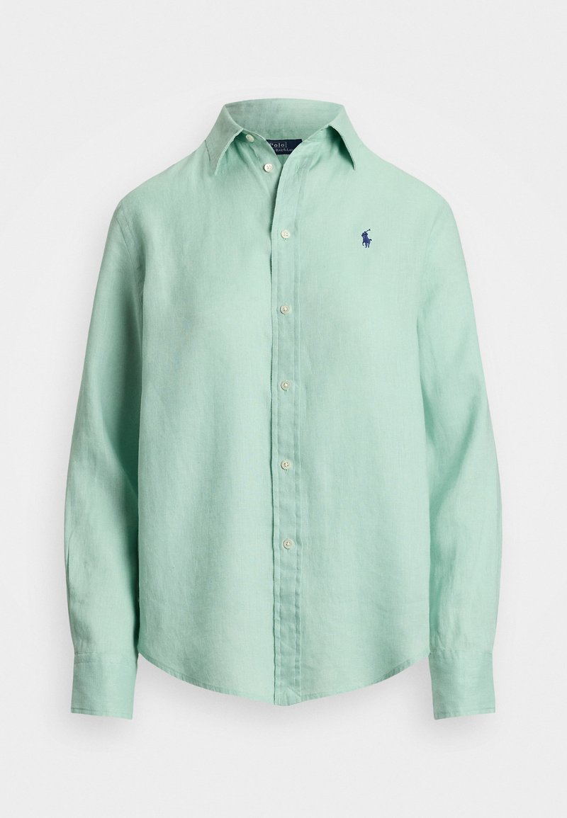 Gaiši zaļš lina krekls ar garām piedurknēm, pogājamu apkakli un mazu tumši zilu logotipu kreisajā krūtī. Mīksta tekstūra, brīvs piegriezums.