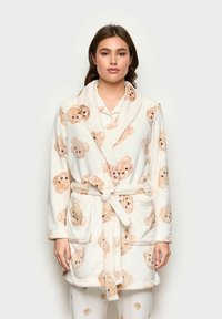 Accappatoio in fleece con una consistenza morbida, caratterizzato da un colore crema e un motivo di facce di orsetto in marrone chiaro. Include una vita con cintura e tasche.