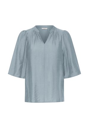 Blouse bleu clair à manches courtes avec un col en V et des détails froncés aux épaules, fabriquée dans un tissu doux et légèrement texturé.