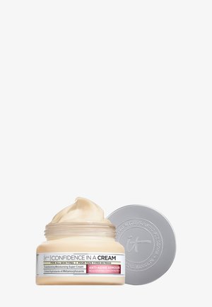 Pot de crème hydratante anti-âge "Confiance en une Crème" avec le couvercle retiré, montrant la texture lisse de la crème à l'intérieur.