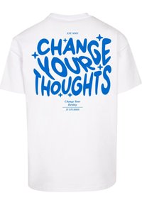 White cotton t-shirt featuring bold blue text on the back: "CHANGE YOUR THOUGHTS" with smaller text above and below. Simple design.