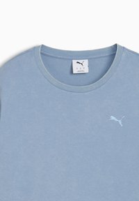 Světle modré bavlněné tričko s kulatým výstřihem, na levé straně hrudi s malým bílým logem Puma. Měkká textura a neformální design.