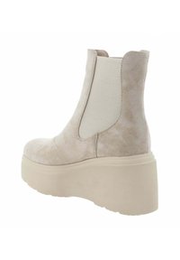 Botín beige de ante con paneles laterales elásticos y una gruesa suela plataforma crema. Cuenta con punta redondeada y una silueta elegante.