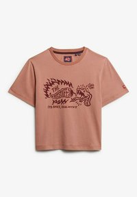 Camiseta corta de manga corta en algodón color rosa que presenta un gráfico con llamas y una mano, etiquetado como "LAS COSAS CALIENTES" y texto debajo.