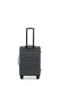 Grijze hard-shell koffer met horizontale richels, twee zwarte wielen en een uitschuifbare handgreep. Gladde textuur en compact ontwerp.